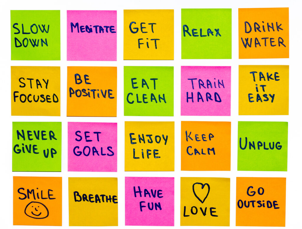 Sticky notes set up with various short and long term goals for sobriety such as drink water, meditate, eat clean, and never give up