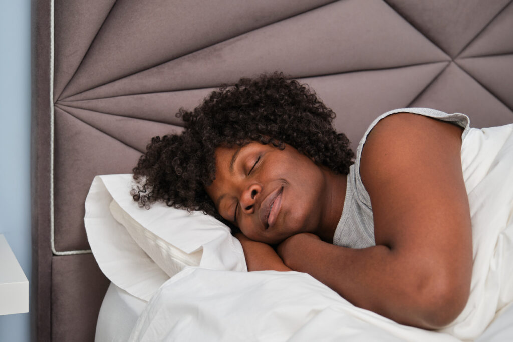 A happy young woman sleeping and recovering her bed