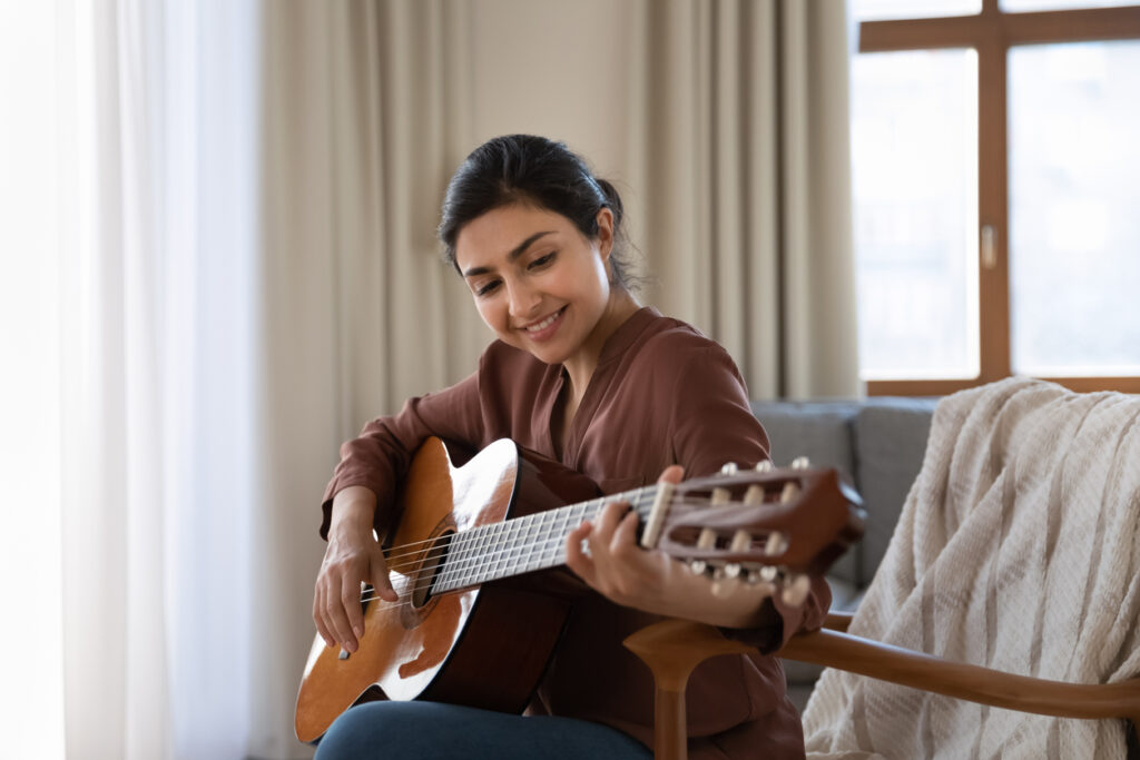 A woman engages in sober hobbies such as playing guitar