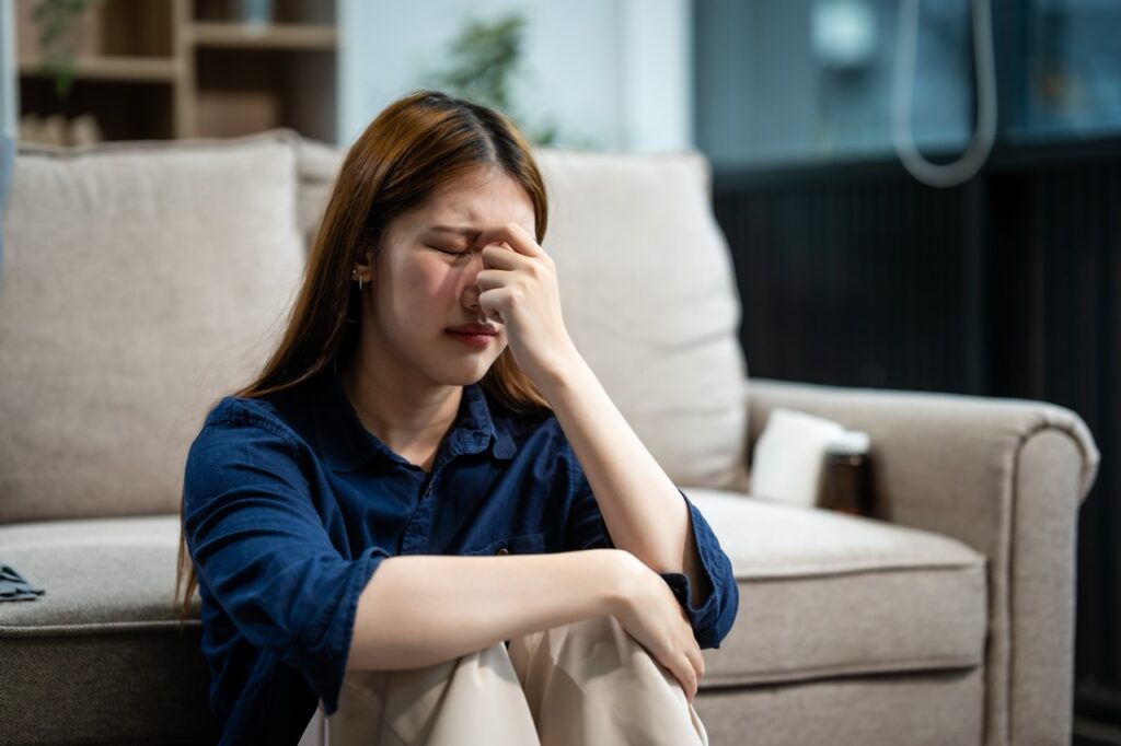 Borderline Personality Disorder vs Bipolar: Are You Getting the Right Treatment for Your Recovery? a,young,asian,woman,sits,on,a,sofa,in,her