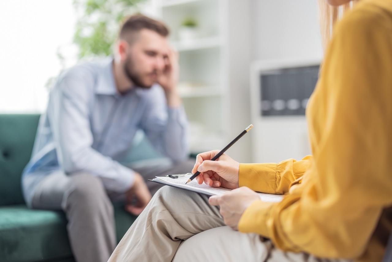 psychologist,doctor,woman,making,notes,during,a,therapy,session,with