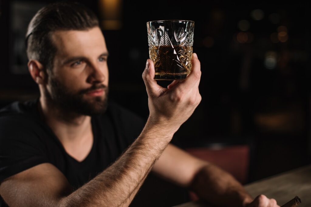 man,sitting,at,bar,counter,and,looking,at,glass,of